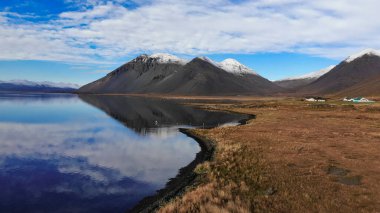 Bulutlu bir günde İzlanda 'daki karlı dağların güzel yansıması.