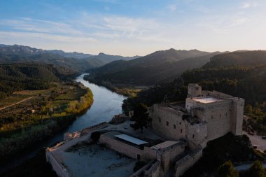 Gün batımında, Ebro nehrinin arka planına sahip Miravet Kalesi 'nin hava manzarası..
