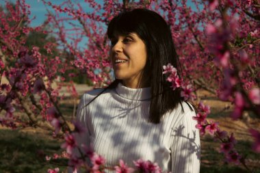 Lleida, İspanya 'da, güzel pembe şeftali çiçeklerinin arasında beyaz bir kadın..