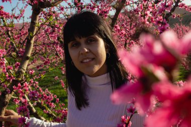 Lleida, İspanya 'da, güzel pembe şeftali çiçeklerinin arasında beyaz bir kadın..