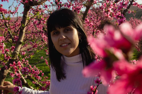 Lleida, İspanya 'da, güzel pembe şeftali çiçeklerinin arasında beyaz bir kadın..