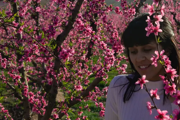 Lleida, İspanya 'da, güzel pembe şeftali çiçeklerinin arasında beyaz bir kadın..