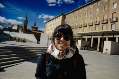 Güneşli bir günde Zaragoza 'daki Plaza del Pilar' dan izleyen mutlu kadın.