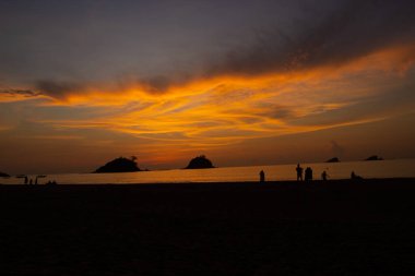 Filipinler, Palawan 'da güzel bir plajda gün batımında el ele tutuşan çift.