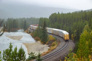 Kanada 'nın Rocky Dağları' ndaki ünlü virajın etrafında at arabalarıyla dolu bir Kanada Ulusal Demiryolu.