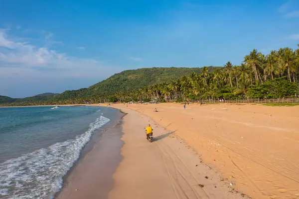 Filipinler 'deki tropikal Nacpan plajında motosikletli sürücü.