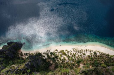 Filipinler 'de, Black Island' da bir teknesi olan tropikal bir sahil manzarası.