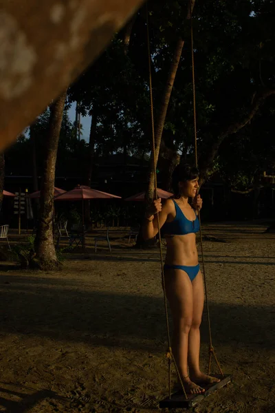 Cennet 'te gün batımında sallanan kadın Lio Sahili, Palawan, Filipinler.