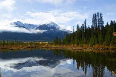 Kanada Banff yakınlarında bulutlu bir günde, sonbaharda, çam ağaçlarıyla dolu Vermilion Gölleri ve Sülfür Dağı 'nın güzel hava manzarası..