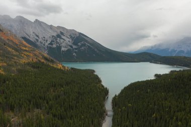 Aerial view of Stewart Canyon at Lake Minnewanka, Banff National Park, Canada. Bridge crosses the river, between mountains full of pines and birch trees. clipart