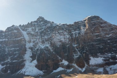 Güneşli bir sonbahar gününde Moraine Gölü yakınlarındaki On Tepe Vadisi 'nin hava görüntüsü dağda karla kaplı..