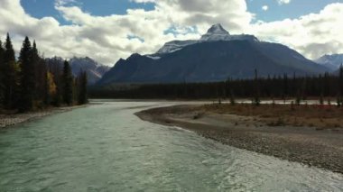 Kanada 'nın Alberta şehrinde bir sonbahar günü binlerce ağaç ve yüksek dağlarla çevrili küçük bir adanın ortasında yer aldığı Athabasca Nehri' nin hava manzarası..