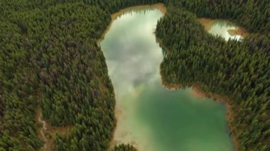 Lorraine 'in binlerce ağaçla çevrili göllerinin gökyüzü bulutlu bir günde göllere yansıyor. Jasper Ulusal Parkı, Kanada.