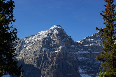 Moraine Gölü yakınlarındaki On Tepe Vadisi güneşli bir sonbahar günü Kanada Kayalıkları 'nda dağda kar yağarken.