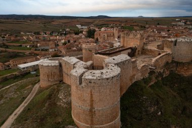 Berlanga del Duero şatosunun panoramik hava manzarası ve bulutlu bir sonbahar gününde kasabanın geri kalanı.