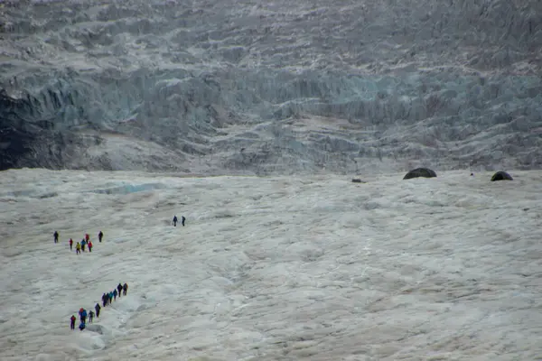 stock image Group of people walking through the Athabasca Glacier - Jasper National Park. Cold winds blow down the Athabasca Glacier in Jasper National Park - Canada.