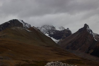 Kanada, Louise Gölü 'nde bulutların kesiştiği karlı dağların hava manzarası..