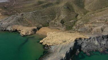 İspanya 'nın Cabo de Palos Murcia kentindeki turkuaz suları ve büyük kayaları ile Cala Dorada' nın küçük kumsalının güzel hava manzarası.