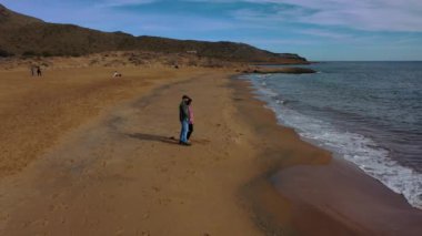 Calblanque sahillerinde günün tadını çıkaran genç bir çiftin hava manzarası.