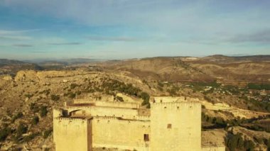 İspanya, Murcia bölgesindeki Mula 'nın etkileyici ortaçağ şatosunun sarp ve kayalık bir tepe üzerindeki hava manzarası.