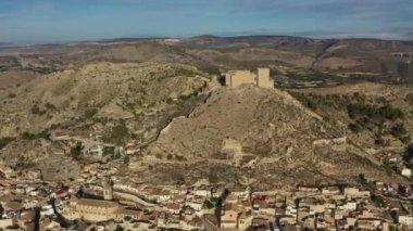İspanya, Murcia bölgesindeki Mula 'nın etkileyici ortaçağ şatosunun sarp ve kayalık bir tepe üzerindeki hava manzarası.