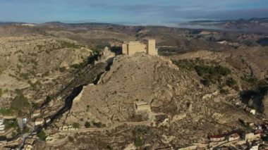 İspanya, Murcia bölgesindeki Mula 'nın etkileyici ortaçağ şatosunun sarp ve kayalık bir tepe üzerindeki hava manzarası.