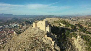 İspanya, Murcia bölgesindeki Mula 'nın etkileyici ortaçağ şatosunun sarp ve kayalık bir tepe üzerindeki hava manzarası.
