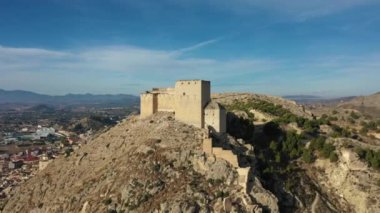 İspanya, Murcia bölgesindeki Mula 'nın etkileyici ortaçağ şatosunun sarp ve kayalık bir tepe üzerindeki hava manzarası.