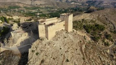 İspanya, Murcia bölgesindeki Mula 'nın etkileyici ortaçağ şatosunun sarp ve kayalık bir tepe üzerindeki hava manzarası.