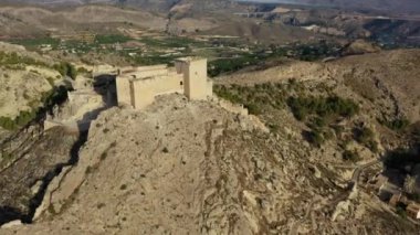 İspanya, Murcia bölgesindeki Mula 'nın etkileyici ortaçağ şatosunun sarp ve kayalık bir tepe üzerindeki hava manzarası.