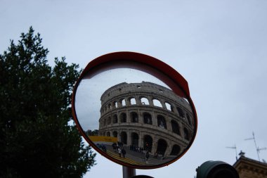 11 / 13 / 2023 Roma, İtalya. Roma 'daki kolezyum bir caddenin aynasından görülüyor..
