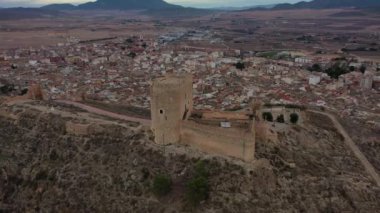 Jumilla Kalesi, Murcia, İspanya 'nın havadan görünüşü. Kulesi, ortaçağ duvarları ve bulutlu gökyüzü.