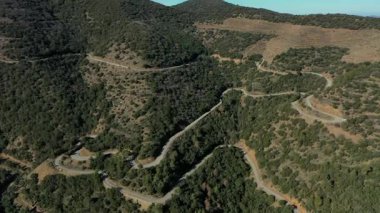 Katalonya, İspanya 'da çam kaplı dağlar arasındaki dolambaçlı bir kır yolunun inanılmaz hava manzarası.