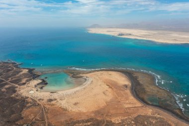 Lobos Adası 'ndaki La Concha Sahili' nin hava fotoğrafında Salinas de Lobos ve Fuerteventura 'nın uçsuz bucaksız silueti yer alıyor..
