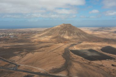 Tindaya Dağı 'nın insansız hava aracı görüntüsü. İspanya' nın Fuerteventura şehrinde efsanevi kutsal bir yer. Gizemli tarihi, doğal güzelliği ve çöl manzarasındaki çarpıcı volkanik varlığıyla tanınıyor..