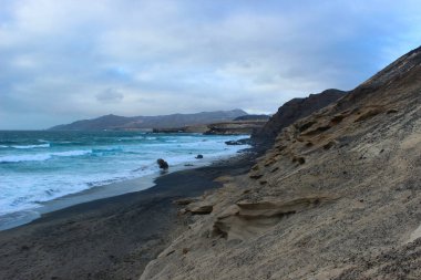 Engebeli kıyı manzarası Fuerteventuras antik jeolojik tarihi sergiliyor