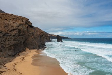 Fuerteventura, Kanarya Adaları 'ndaki ikonik Roque del Moro kaya oluşumuyla Coffee Beach' in nefes kesici hava manzarası..