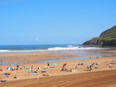 Kumsalda insanlar, arka planda dalgalar...