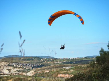 Yamaç paraşütü denizin üzerinde uçar. Bizkaia 'da yaz aylarında çok popüler olan bir etkinlik. İnsanlar unutulmaz bir gün geçirmek için bu ekstrem spora başvuruyorlar..