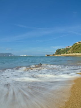 Sahilde kayalar ve dalgalar kıyıya vuruyor.