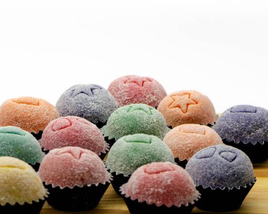 Beyaz arka planda, ahşap bir masanın üzerinde renkli tugaylar izole edilmiş.