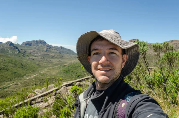 Selfie of a young adventurer traveling with backpack hikingin the mountains in Brazil