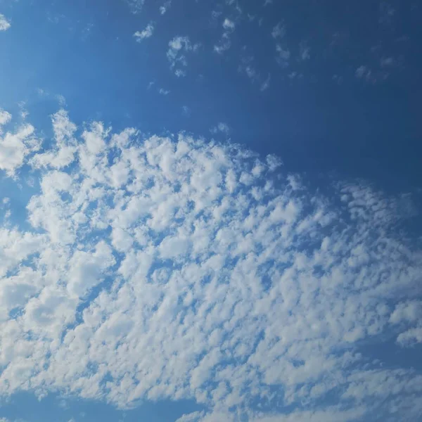 Yumuşak bulutların üzerindeki chiaroscuro Mavi gökyüzünde güneş ışığı