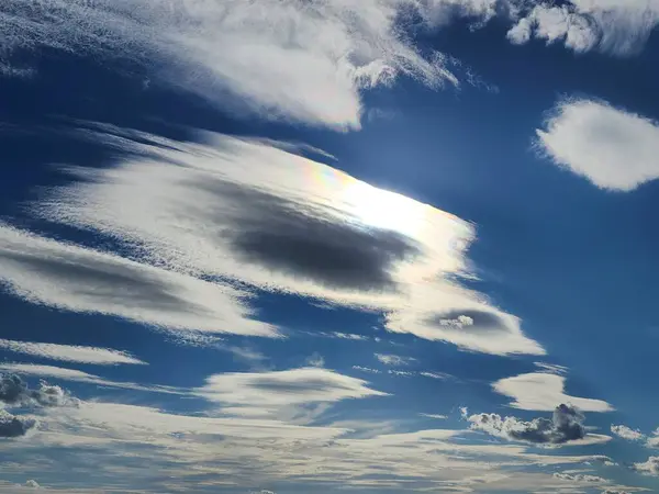 dramatik arka planda zıt bulutlar. Altostratus bulutları güneşli arka planda derin mavi gökyüzünde