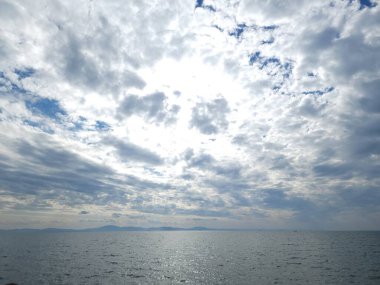 Denizin üzerindeki bulutlu gökyüzünün gümüşi manzarası