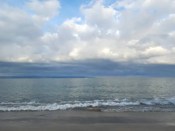 Muhteşem kümülüs bulutları denizin parlak yüzeyine yansıyor.