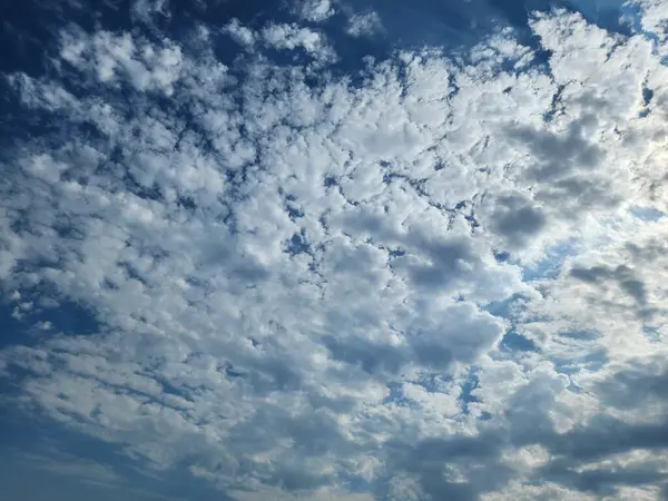 Güneş altokümülüs bulutlarının arasından parlar. Yukarı bakıyorum.