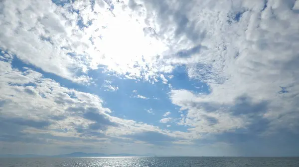 Güneşli bir günde denizin üzerindeki bulutlu gökyüzü manzarası