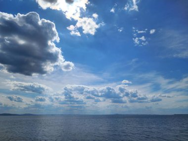 Mavi gökyüzü ve bulutlar deniz yüzeyine inanılmaz bir deniz manzarası yansıyor.