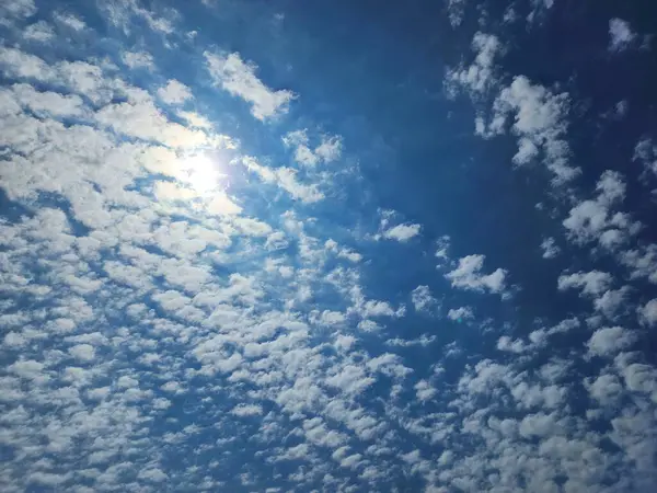 Beyaz yumuşak altokülüs bulutları parlak güneşli mavi gökyüzünde